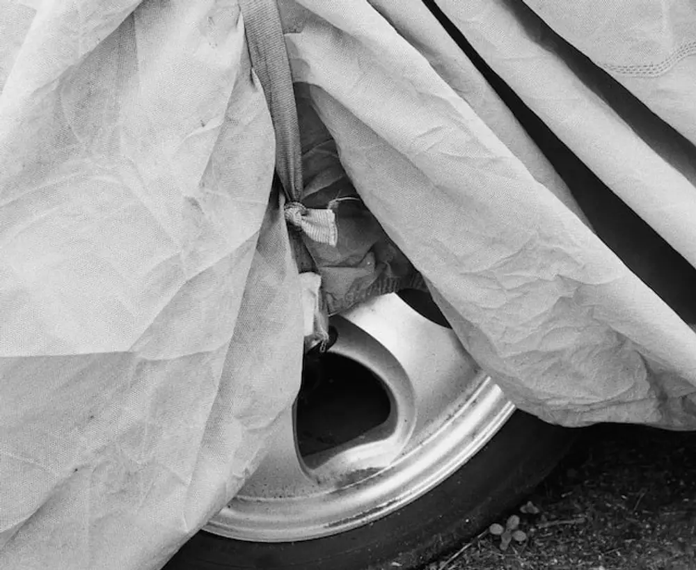 Car cover secured with strap to wheel for how to make sure your car cover doesn’t blow off